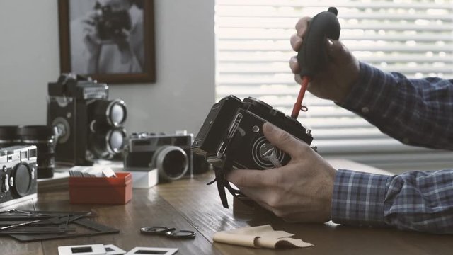 Professional photographer cleaning a twin lens camera