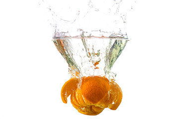 Fresh mandarin falling in water splash, isolated on white.