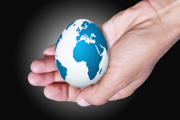 Easter egg in hand / Easter egg with drawing of the card of the planet Land in hand of the person