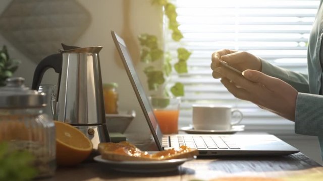 Woman using her laptop in the kitchen