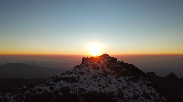 aerial view of unrecognizible climbers on summit of the Lenana peak of Mount Kenya during sunrise