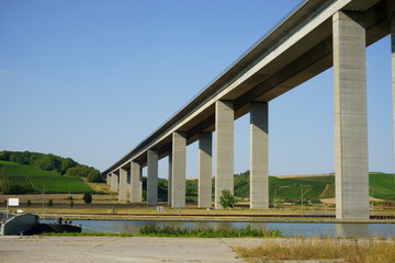 Fototapeta na wymiar concrete highway bridge across a river valley in Germany under blue sky