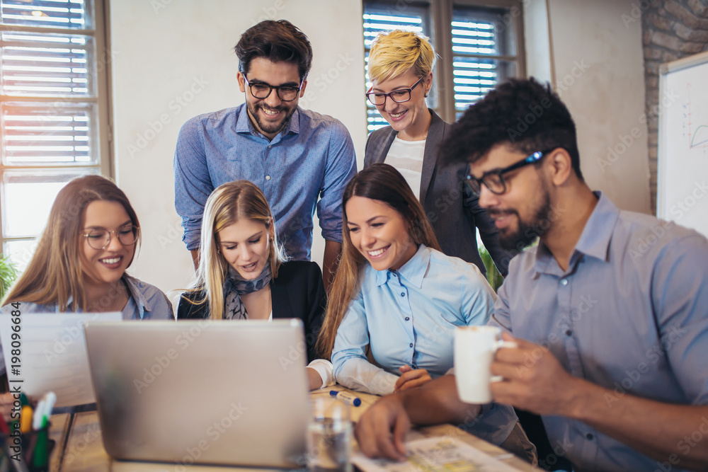 Wall mural  Group of young business people in smart casual wear working together in creative office