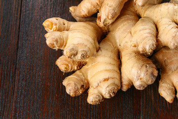Spicy root of ginger on a wooden table.