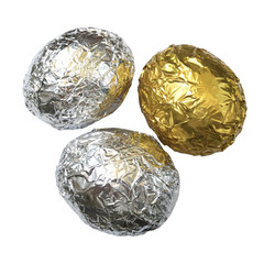 One golden and two silver eggs on a white background.Eggs covered with crumpled foil