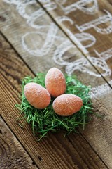 easter eggs in decorative nest standing on wooden table