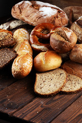 Different kinds of bread and bread rolls on board from above. Kitchen or bakery poster design