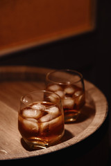 Glass of whiskey on wooden background close up
