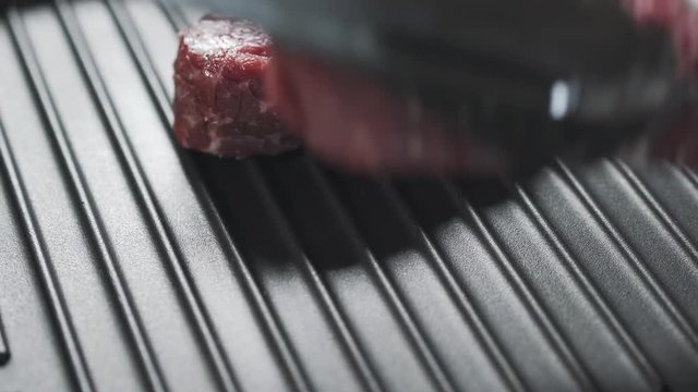 putting steaks filet mignon on a grill pan
