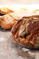 Different kinds of bread and bread rolls on board from above. Kitchen or bakery poster design
