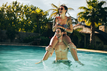 Young couple having fun in swimming pool