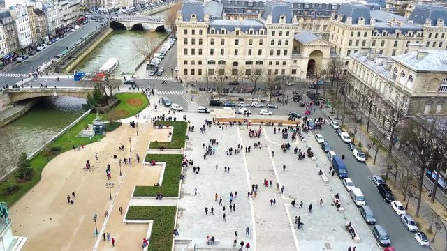 Aerial view of Parvis Notre-Dame - Place Jean-Paul II in front of the tall gothic arches of the western entrance to the Notre-Dame Cathedral.