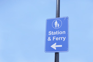 Station and ferry direction sign post large blank blue sky background