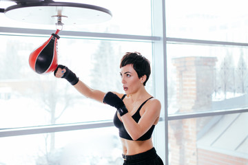sede view shot of pleasant female in black sportswear dealing a blow to little red and black speed...