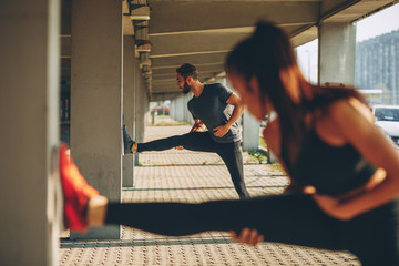 Young sports couple exercising in the urban environment