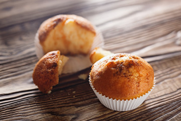 Classic muffins on a wooden old background in a white wrapper.