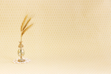 glass vase with a few ripe spikelets of rye Secale cereale on a white round knitted napkin on a...