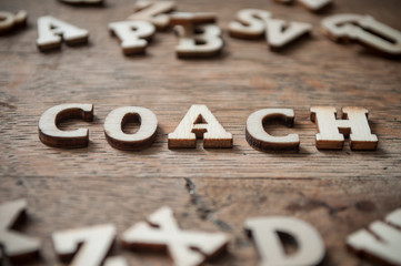 concept wooden letters on wooden table background - Coach
