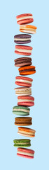 French macarons large falling arrangement stacked up on blue background in studio