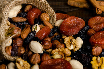 nuts, dried fruits, pistachios and other scattered from the bag on the table