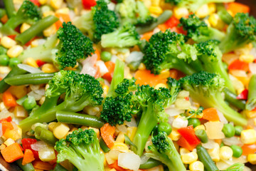 Fresh vegetables in a frying pan. Fresh vegetable products, freshly frozen odietic vegetables carrots are cooked in a frying pan on a gas stove.