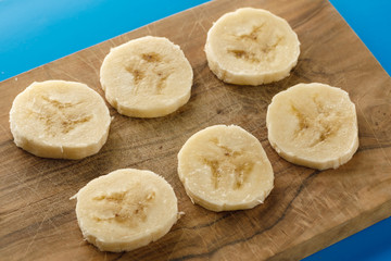 Banana slices on a wooden board