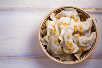 Plate of pierogi or varenyky, vareniki, Dumplings, filled with beef meat and served with fried onion. Pyrohy - dumplings with filling. View from above, top, overhead