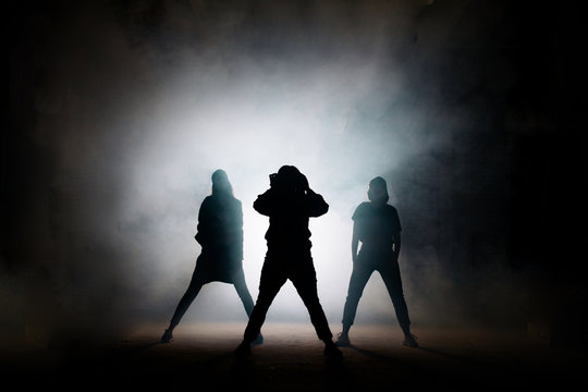 portrait of singer with her dancers on the black background. good performance. the beggining of show. the end of performence