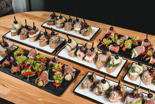 tasty pinchos with tuna, chorizos, salmon, egg, dried tomatoes, avocado, salmon, bacon, Hamon, Brie Cheese, Olives and Pesto Sauce, traditional spanish snack