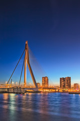 Travel Concepts. View of Unique and Beautiful Erasmus Bridge in Rotterdam. City Scyline on the Background. Shot Made During Blue Hour.