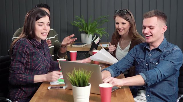 Team Of Young Employees Looking At The Data On The Laptop, Indoor Shot Of Happy Reaction To Successful Result While Working In Dark Green Office