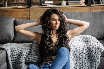 Obraz premium cute young woman sitting on the floor in blue jeans and blue shirt, fashion