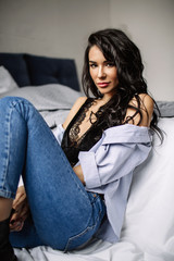 cute young woman sitting on the floor in blue jeans and blue shirt, fashion