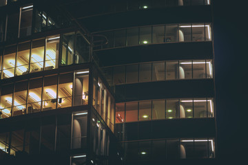 Modern office building made from glass at night time. Lights in the office windows. Modern...