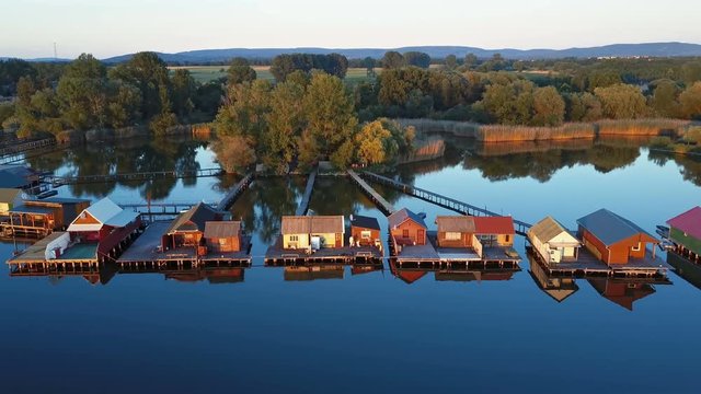 Aerial panorama of traditional fishing houses line on the lake shore, Hungary.