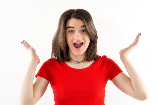 Portrait of a beautiful surprised or amazed young woman wearing red t-shirt, white background. Emotions