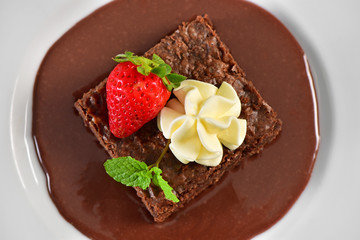 Brownie, chocolate sauce, chantilly and strawberry