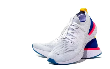 Fotobehang White sport shoes on isolated white background with copy text space © vachcameraman