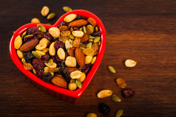 Energy Blend Trail Mix with Nuts and Dried Fruits in Heart Shaped Bowl. Selective focus.
