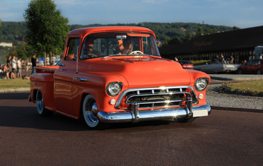 Obraz na płótnie Canvas Old american chevrolet pickup truck on the road. Vintage car orange truck - retro style. 