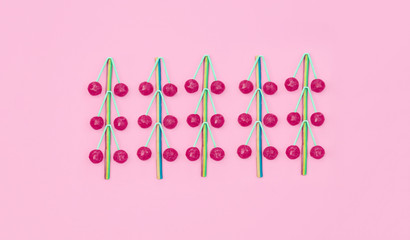 Assorted colored lollipops on pink background.