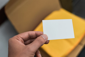 Closeup on hand with letter craft envelope on the background. Receiving and sending commercial or personal package, top view communication conceptual design