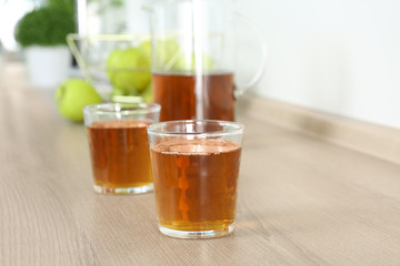 Glasses of fresh apple juice on wooden table