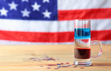 Layered cocktail in colors of American flag on wooden table