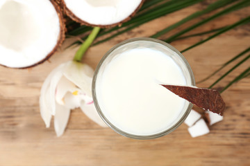 Glass of coconut milk on wooden background, closeup