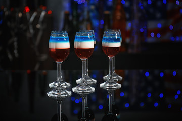 Layered cocktails in colors of American flag on table