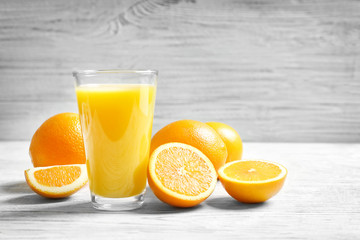 Glass of orange juice and fresh fruits on table