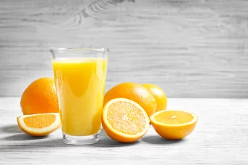 Printed kitchen splashbacks Juice Glass of orange juice and fresh fruits on table