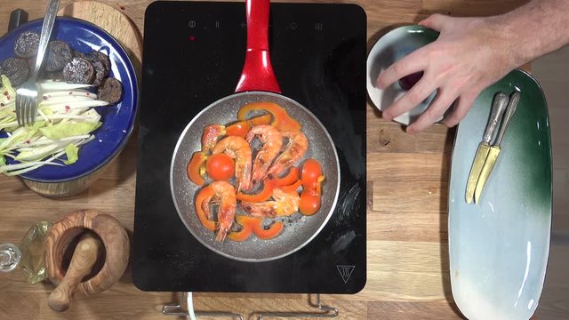Top view food preparation Shrimp and violet potatoes to the pan on the stove with induction