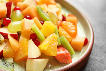 Fototapeta na wymiar Plate with fresh cut fruits on table, closeup